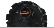Orangefarbener Stecker wird aus der Kamera&ouml;ffnung der Objektivkappe gezogen.